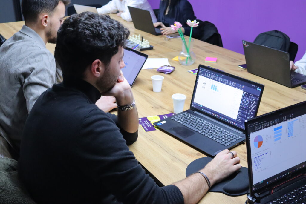 “Studentë të rinj duke punuar në laptop në një akademi moderne në Kosovë”